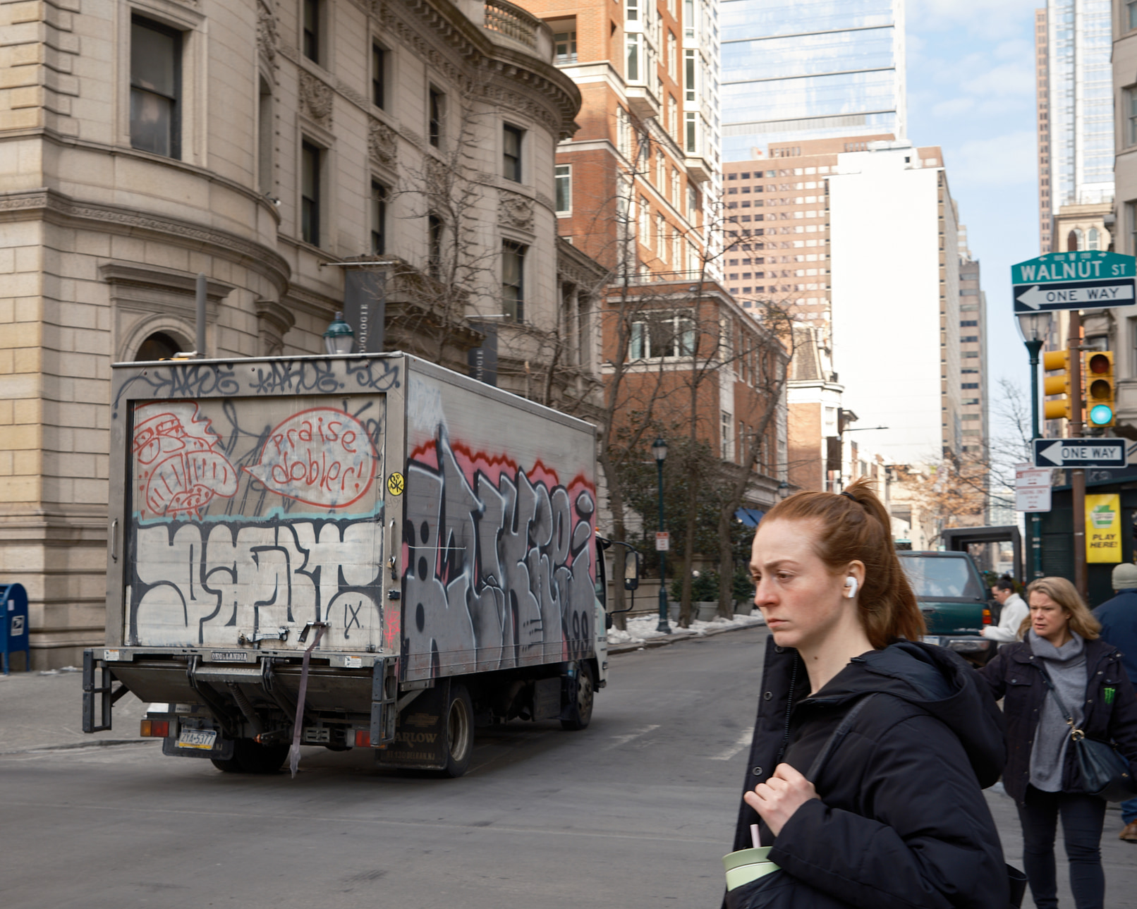 Slightly out of focus graffiti truck and women on Walnut St.