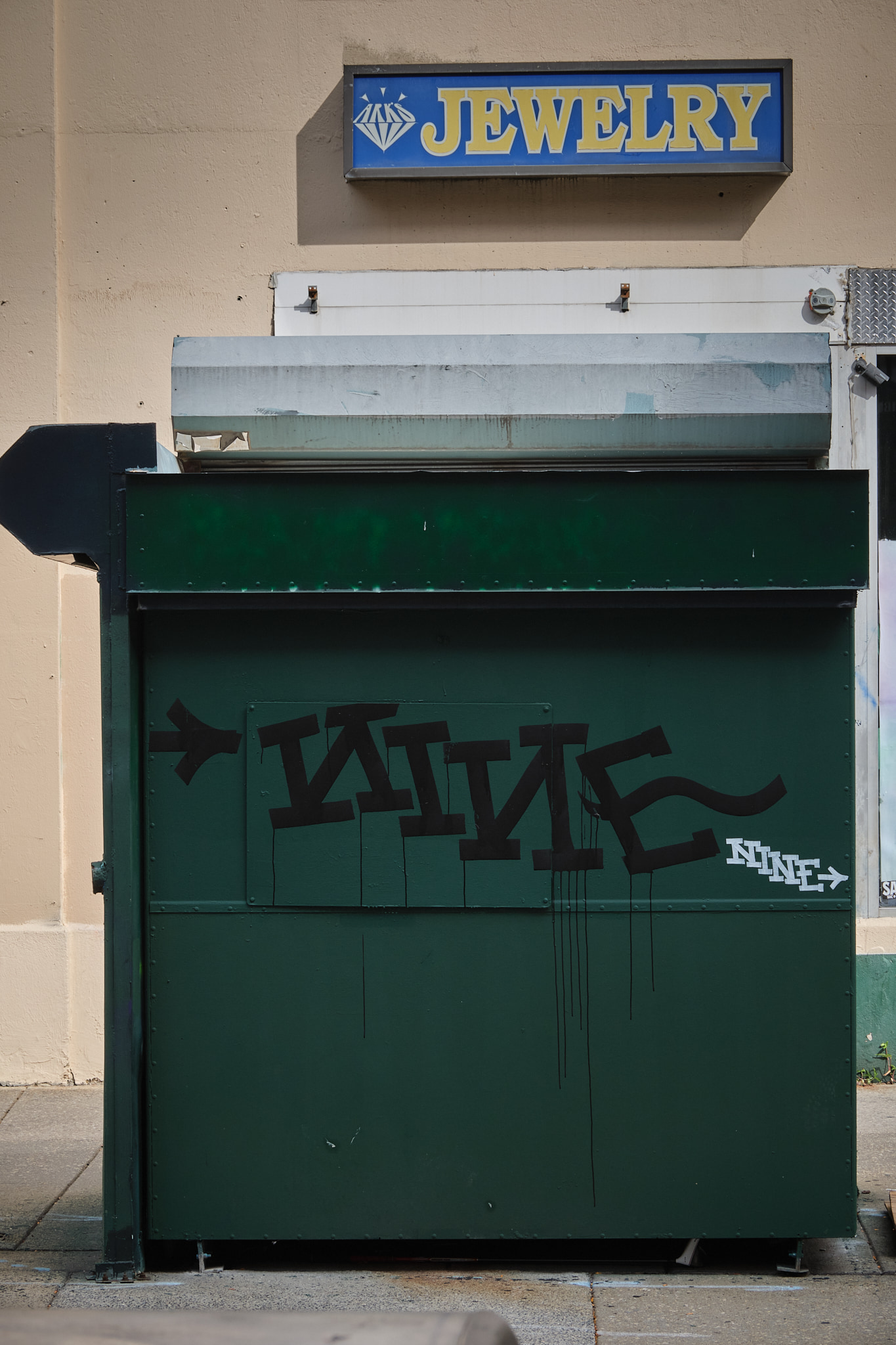 Newspaper stand with graffiti.