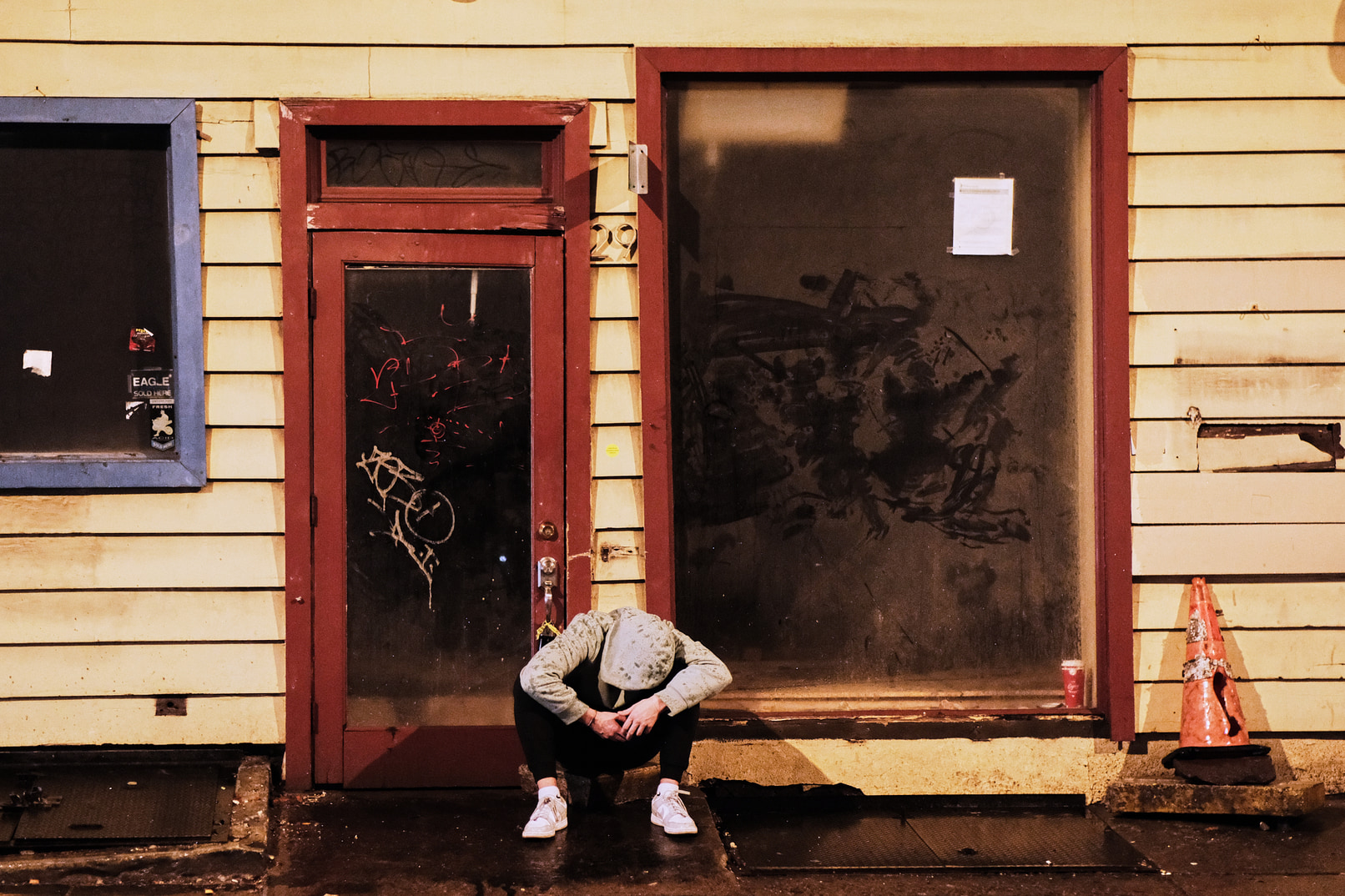 Drunk youth resting on steps of vacant business