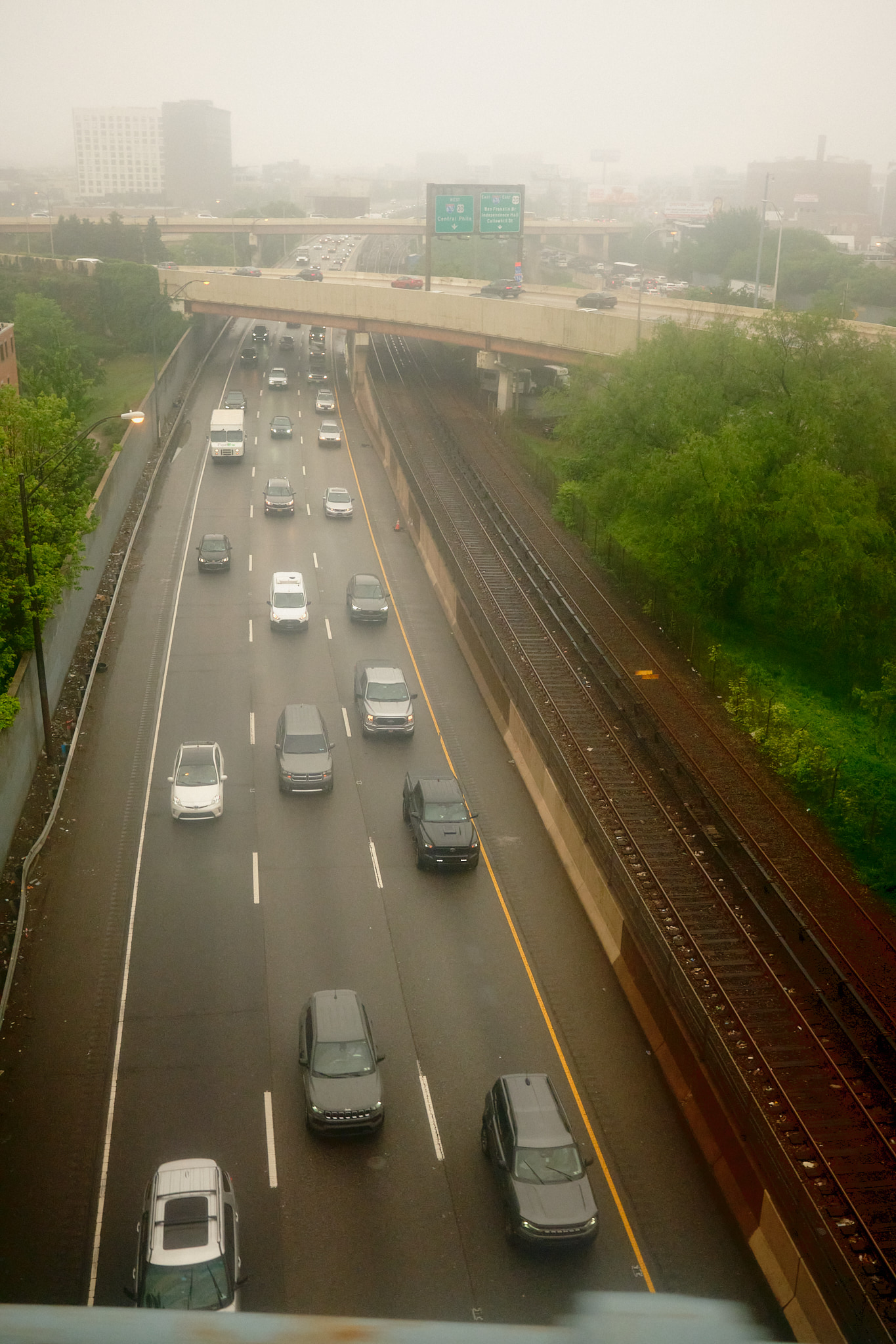 Bird's eye view of cars traveling a highway on foggy morning.