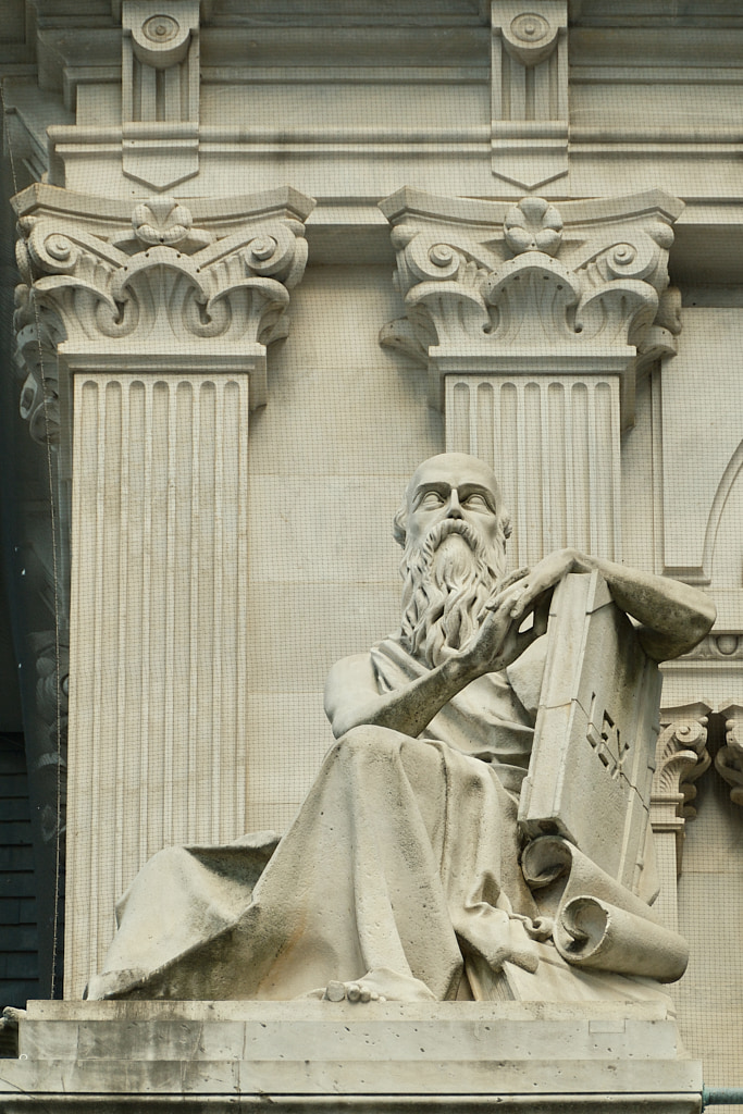 Sculpture of old man with beard holding a large book titled LEX.