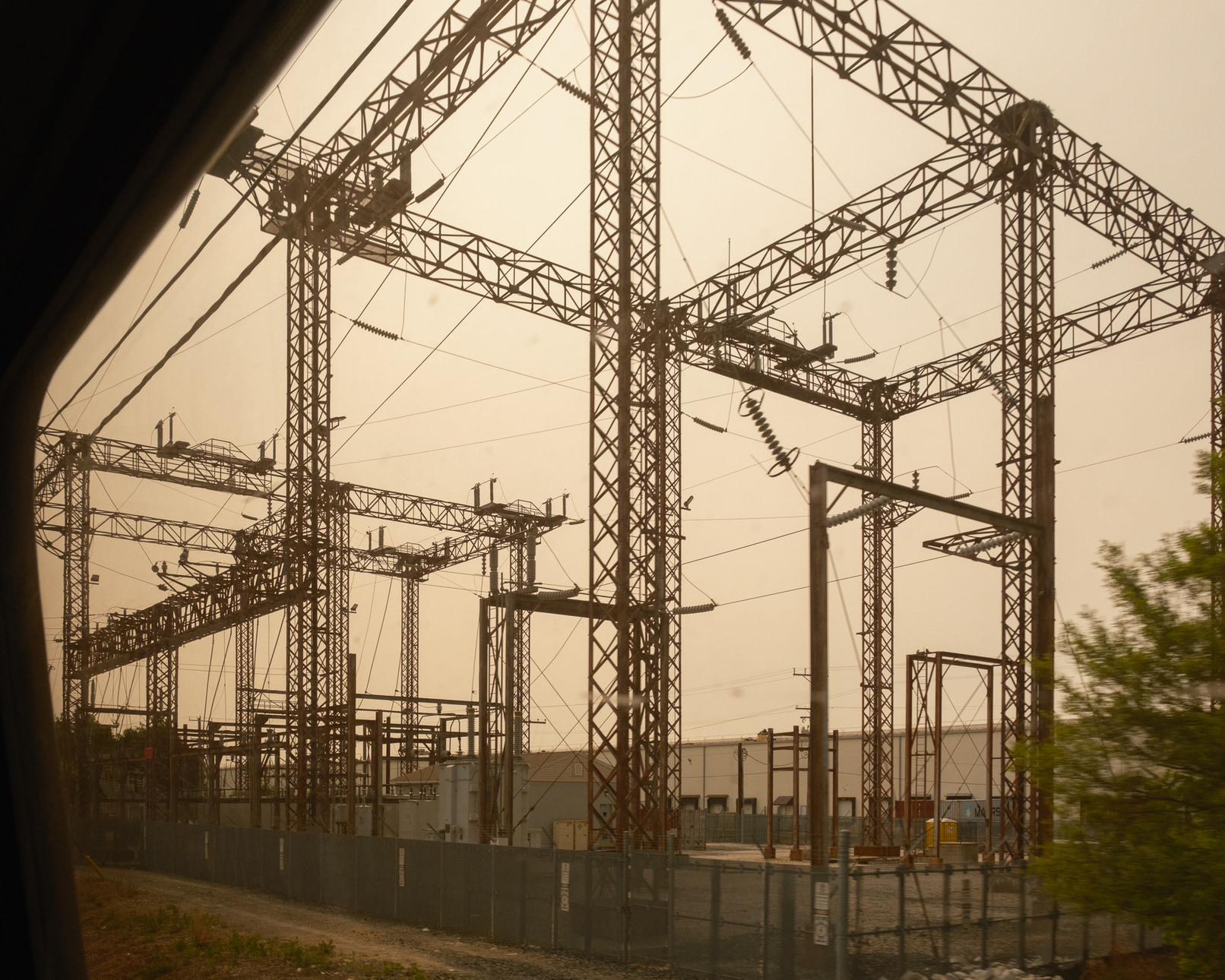 The power grid is seen through a dirty train window