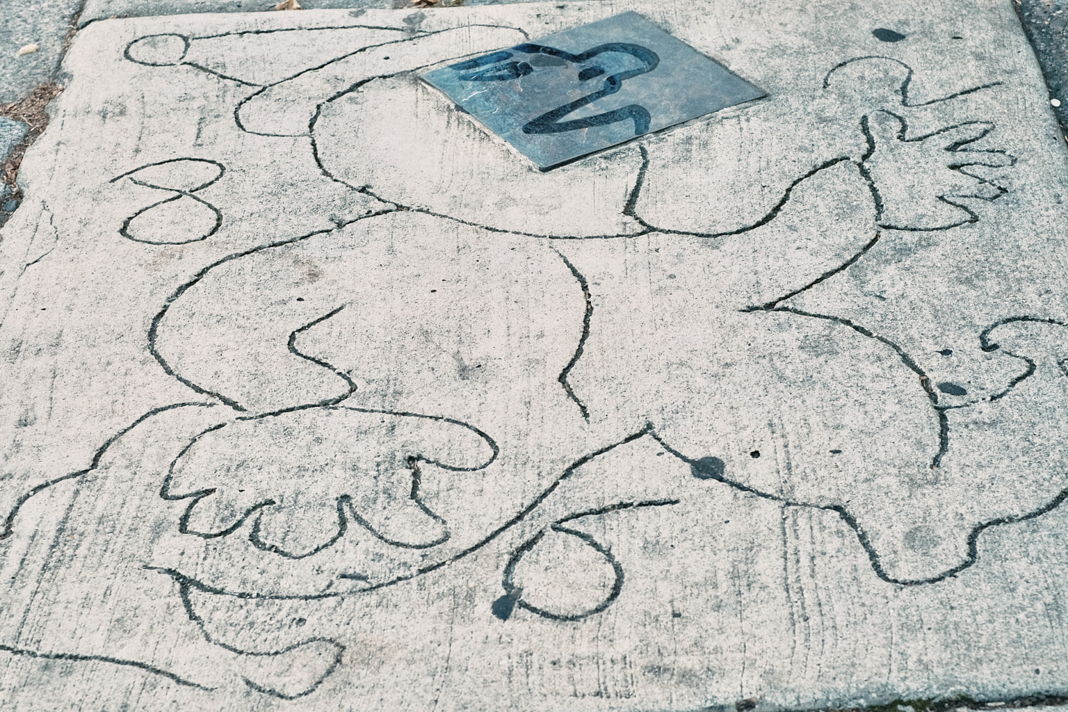 Cartoon of a juggling jester drawn in wet cement that has now dried